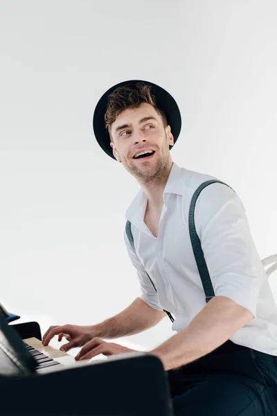 Pianista alegre em camisa branca e chapéu preto tocando piano — Fotografia de Stock