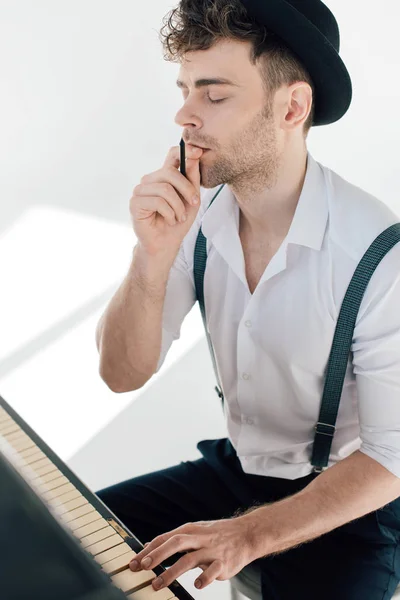 Uomo premuroso comporre musica mentre seduto al pianoforte — Foto stock