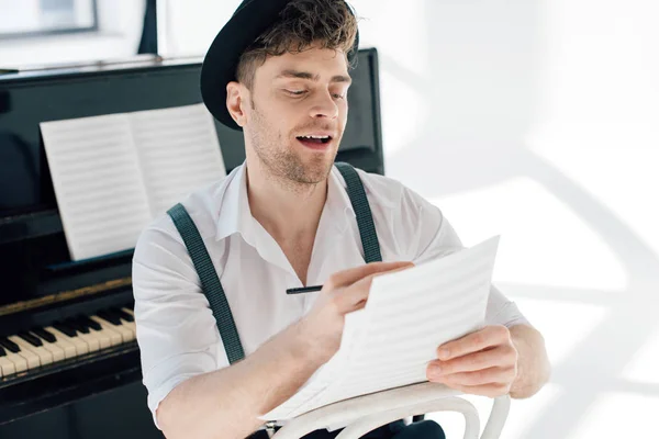 Selective focus of cheerful man composing music at home — Stock Photo