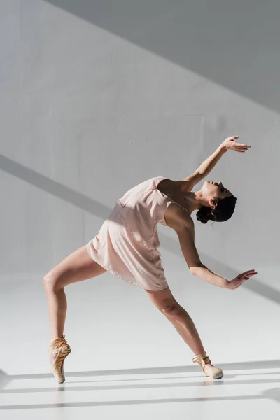 Bailarina jovem dançando em vestido rosa e sapatos pontiagudos — Fotografia de Stock