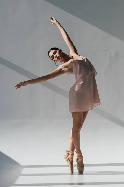 Elegante bailarina en vestido rosa bailando a la luz del sol - foto de stock