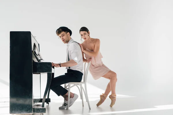 Bailarina atraente tocando músico bonito tocando piano — Fotografia de Stock