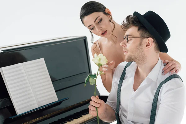 Hermoso pianista regalando rosa a hermosa joven bailarina - foto de stock