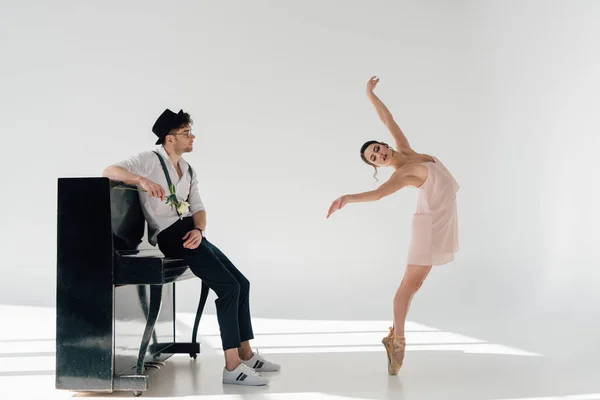 Hermoso músico sosteniendo rosa y mirando bailando hermosa bailarina - foto de stock