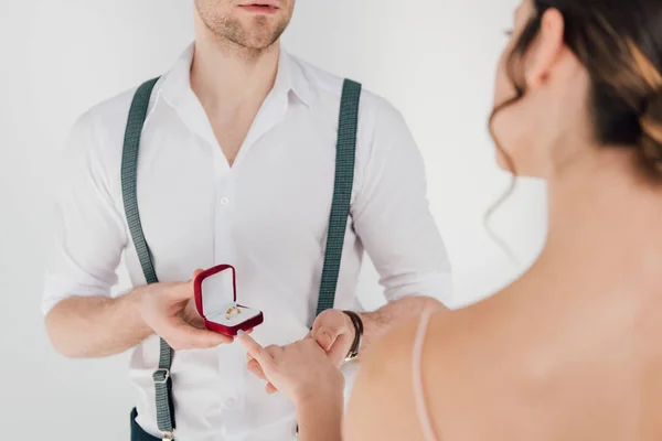 Hombre vista recortada en camisa blanca haciendo propuesta de boda a la mujer joven - foto de stock