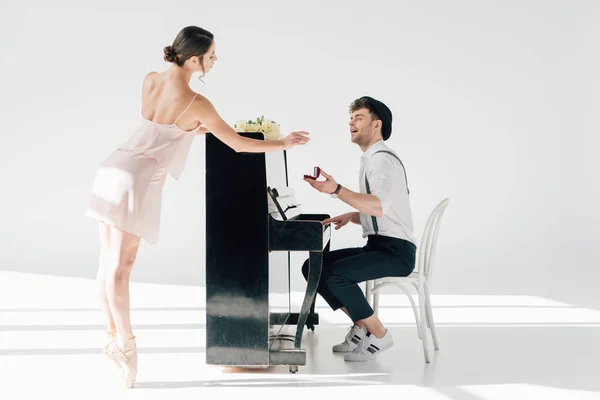 Beau musicien jouant du piano tout en faisant la demande en mariage à la belle ballerine — Photo de stock