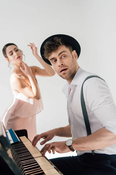 Selektiver Fokus des Musikers beim Klavierspielen, während junge Ballerina im rosa Kleid tanzt — Stockfoto