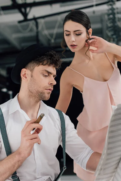 Beautiful ballerina standing near concentrated musician looking at music book — Stock Photo