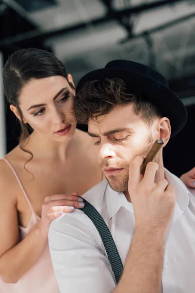 Beautiful girl touching shoulder of confident man holding sigar — Stock Photo