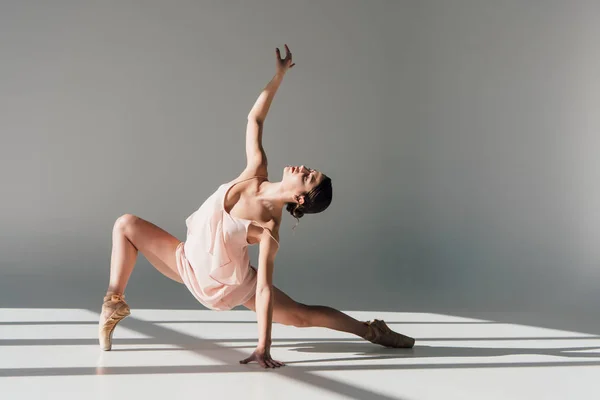 Graziosa giovane ballerina in abito rosa che danza alla luce del sole — Foto stock