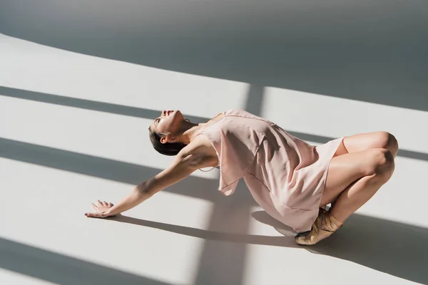 Hermosa bailarina joven en vestido rosa bailando a la luz del sol - foto de stock