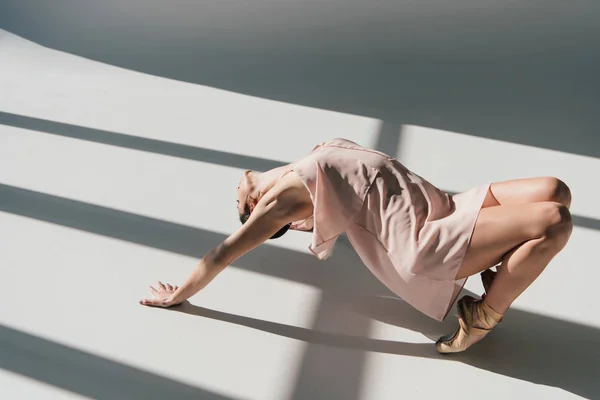 Beautiful young ballerina in pink dress dancing in sunlight — Stock Photo