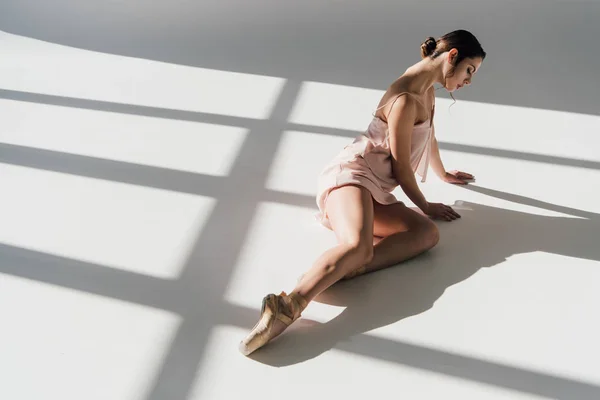 Bailarina atraente em vestido rosa sentado à luz do sol — Fotografia de Stock