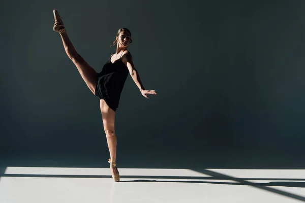 Привлекательная балерина танцует в черном платье и пуантах — стоковое фото