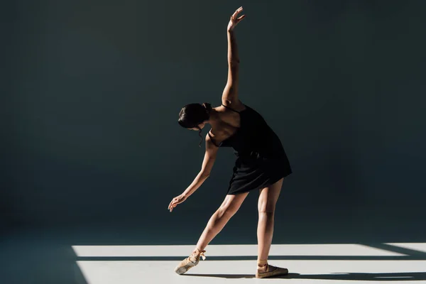 Приваблива молода балерина танцює в чорній сукні — стокове фото