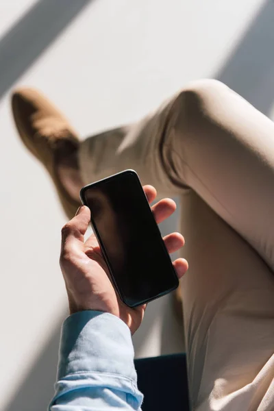 Foyer sélectif du smartphone avec écran blanc à la main masculine — Photo de stock