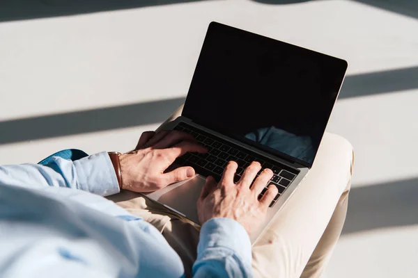 Selective focus of man using laptop with blank screen — Stock Photo