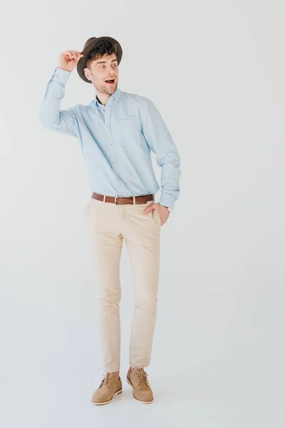 Heureux bel homme en chemise bleue et jean beige avec la main dans la poche isolé sur gris — Photo de stock