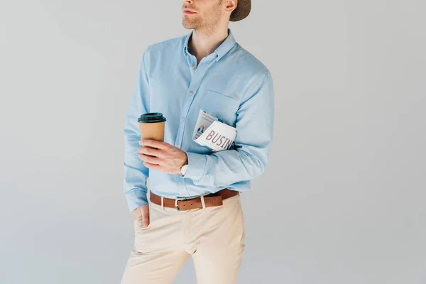 Частичный взгляд человека с деловой газетой и бумажной чашкой изолированы на сером — стоковое фото