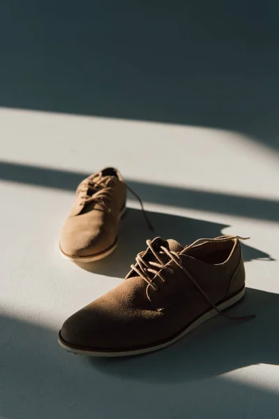 Foyer sélectif de chaussures en daim beige sur le sol à la lumière du soleil — Photo de stock