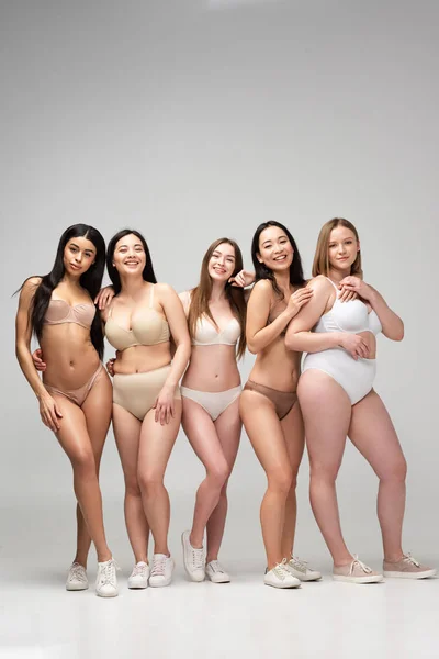 Five pretty multiethnic girls in lingerie looking at camera and smiling, body positivity concept — Stock Photo