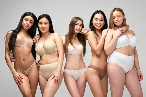 Cinque attraenti giovani donne multietniche in biancheria intima in posa davanti alla fotocamera isolata sul grigio, concetto di positività del corpo — Foto stock