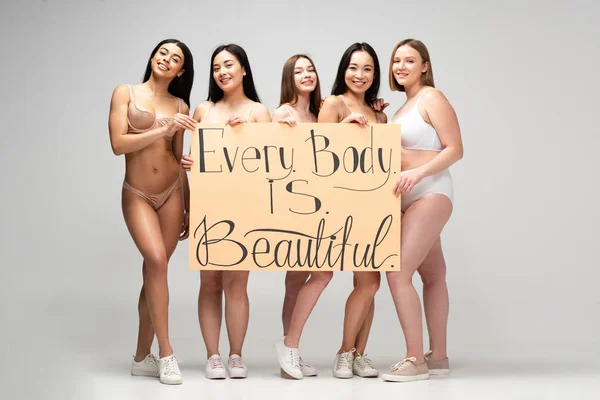 Cinco chicas muy multiculturales sosteniendo pancarta con 