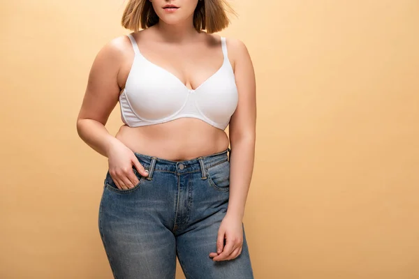 Abgeschnittene Ansicht eines übergewichtigen Mädchens, das die Hand in der Tasche hält, isoliert auf beige, Body Positivity Konzept — Stockfoto