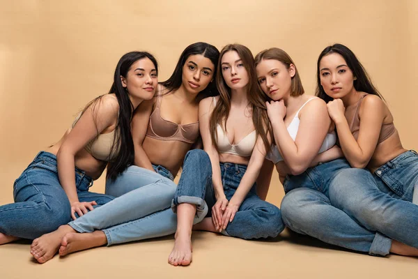 Five dreamy multicultural girls sitting and looking at camera, body positivity concept — Stock Photo