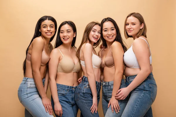 П'ять красивих мультикультурних дівчат посміхаються, позуючи на камеру ізольовані на бежевому, концепції позитиву тіла — стокове фото