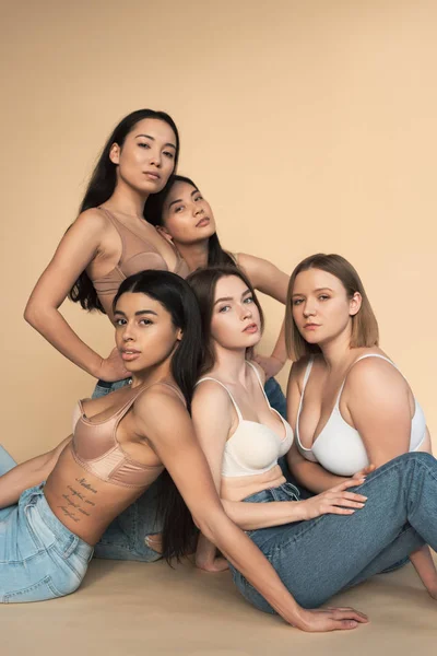 Cinq femmes multiculturelles en jeans et soutiens-gorge bleu regardant caméra, concept de positivité du corps — Photo de stock