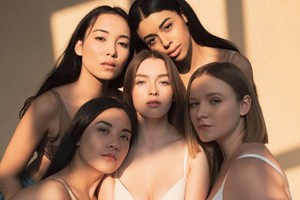 Fünf schöne multikulturelle junge Frauen, die im Sonnenlicht in die Kamera schauen — Stockfoto