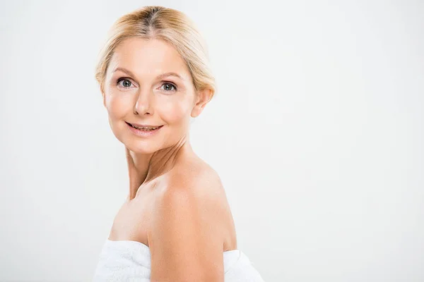 Attractive and smiling mature woman looking at camera isolated on grey — Stock Photo