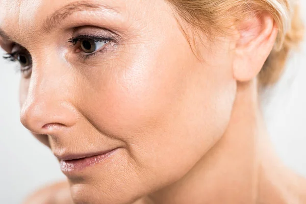 Selective focus of beautiful mature woman looking away isolated on grey — Stock Photo