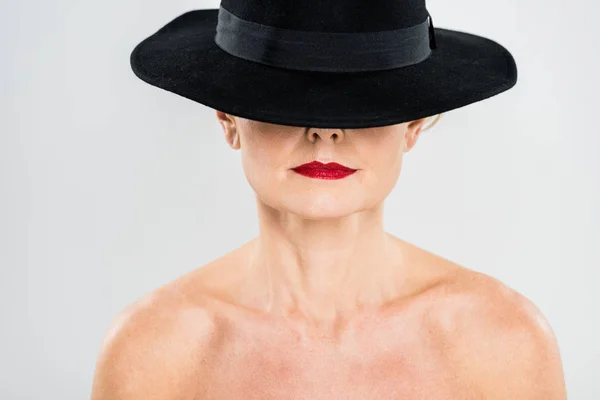 Donna di mezza età elegante e alla moda con labbra rosse in cappello nero isolato su grigio — Foto stock