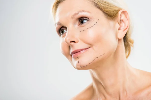 Belle femme d'âge moyen avec des lignes sur le visage regardant la caméra sur fond gris — Photo de stock