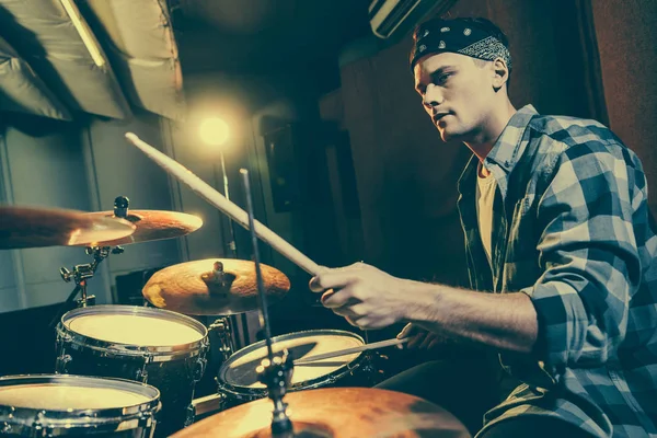 Вибірковий фокус красивого барабанщика, який тримає барабанні палички під час гри на барабанах — стокове фото
