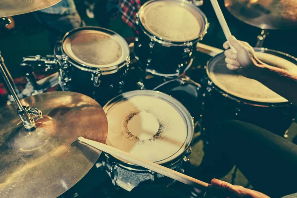 Vue recadrée du batteur tenant des baguettes de tambour tout en jouant de la batterie — Photo de stock