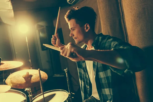 Красивий барабанщик тримає барабанні палички і грає на барабанах — стокове фото