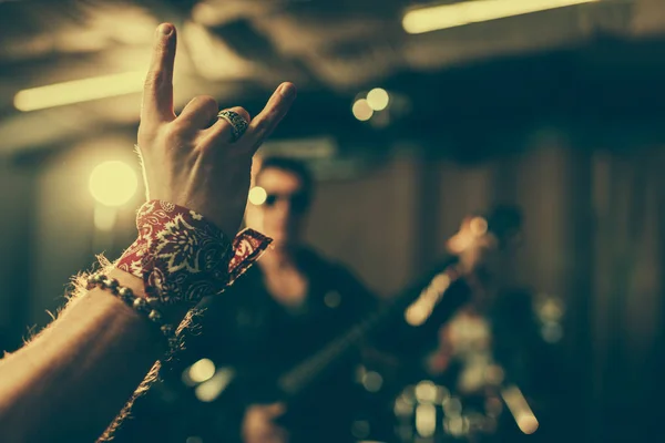 Enfoque selectivo del hombre mostrando signo de rock cerca de músico - foto de stock