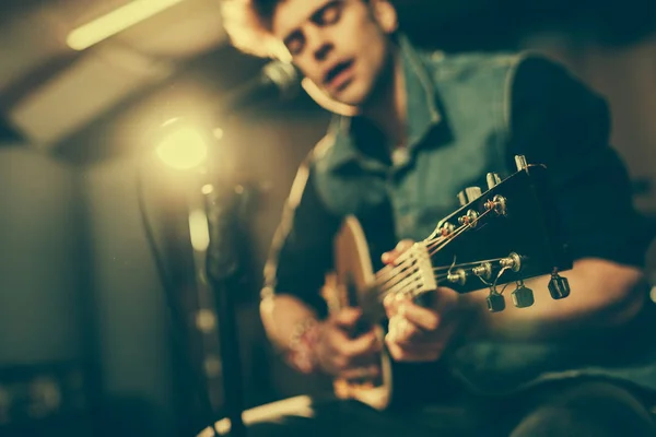 Foyer sélectif de guitare acoustique dans les mains du chanteur près du microphone — Photo de stock