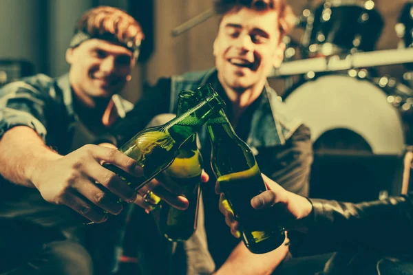 Foco selectivo de botellas de vidrio en manos de amigos alegres - foto de stock