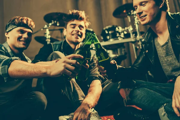 Foco seletivo de amigos alegres batendo garrafas de vidro de cerveja — Fotografia de Stock