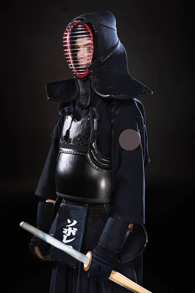 Kendo combattente in armatura con spada di bambù sul nero — Foto stock