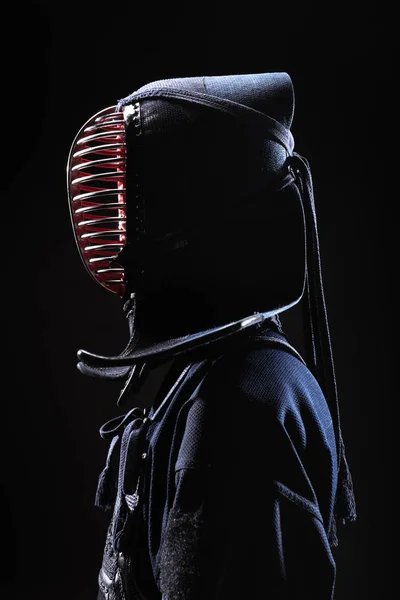 Side view of kendo fighter in traditional helmet isolated on black — Stock Photo