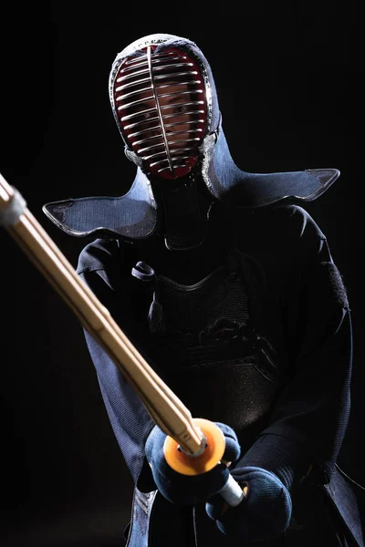 Combattant Kendo en armure pratiquant avec épée de bambou sur noir — Photo de stock