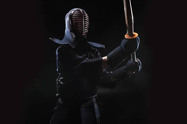 Kendo fighter in armor practicing with bamboo sword on black — Stock Photo