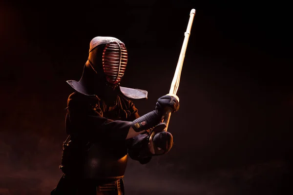 Kendo lutador em armadura praticando com espada de bambu em preto — Fotografia de Stock