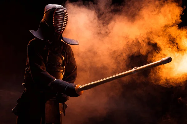 Kendo lutador em armadura praticando com espada de bambu em fumaça — Fotografia de Stock