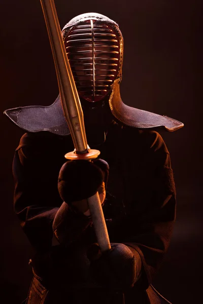 Combatiente Kendo en armadura sosteniendo espada de bambú en humo - foto de stock